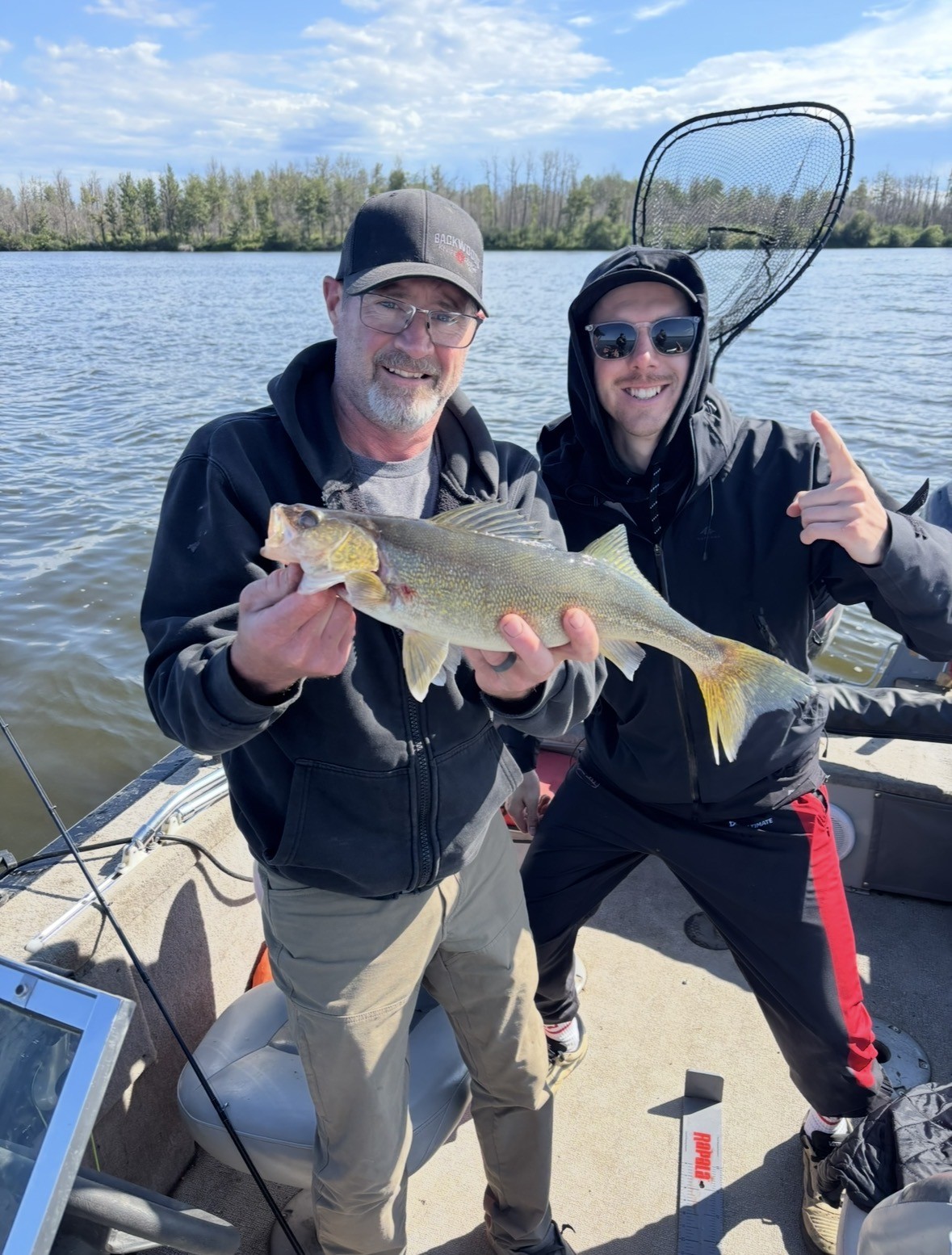 Father and son with a walleye on the river